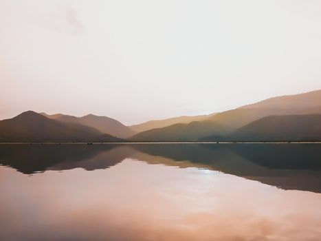 Panorama scenic of beautiful sunset at the lake with mountain ranges on background. Minimal nature.