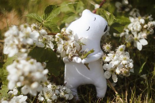 Eco-friendly cute handmade toy bear on grass at sunny summer day
