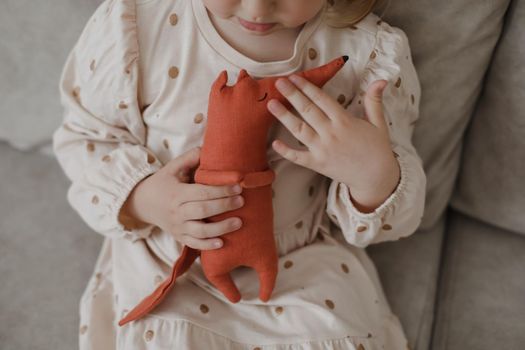 Little girl holding a toy at home. Happy child