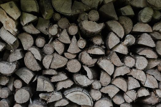 pile stacked natural sawn wooden logs background. Background of birch logs, stacked on top of each other. Wall of stacked wood logs as background