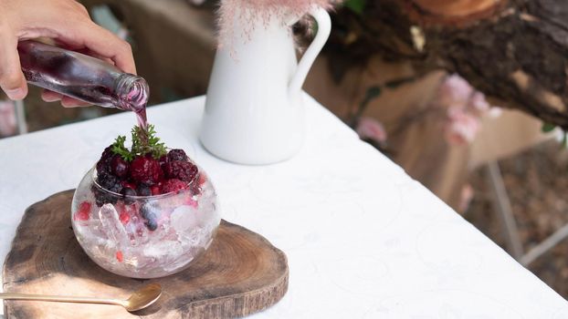 Man pour delicious nonalcoholic Raspberry Mojito which combines fresh raspberries, juicy lime and crisp mint in glass