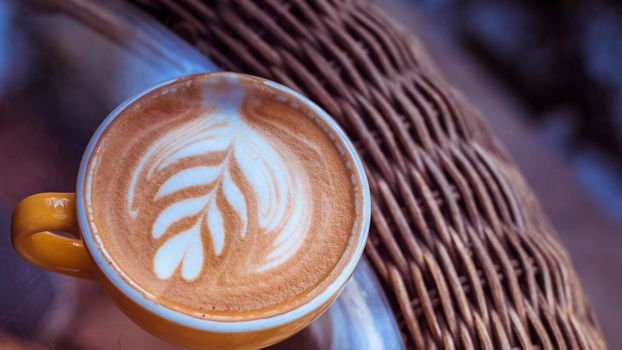 Hot Latte on woven table.Close up Coffee Art Leaf Design .Art of  Latte Espresso