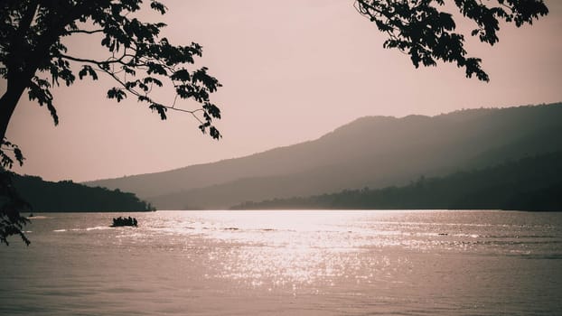 light reflection by surface waves of a lake at sunset with mountain background.