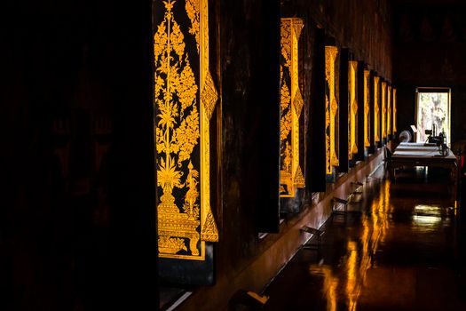 Traditional Thai art  courage engraved painting in Buddhist window at Wat Bowon Sathan Sutthawat.