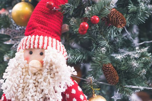 Happy santa claus decoration on the table with christmas tree bokeh on background