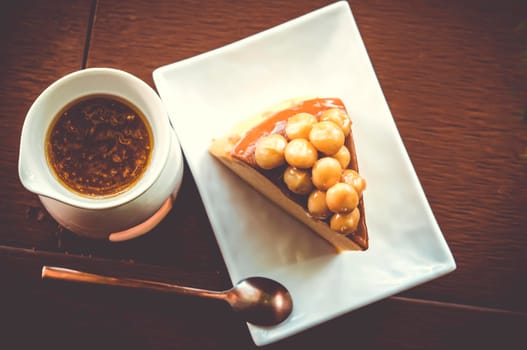 Macadamia Caramel Cake homemade dessert sweet cake on white ceramic plate with spoon.
