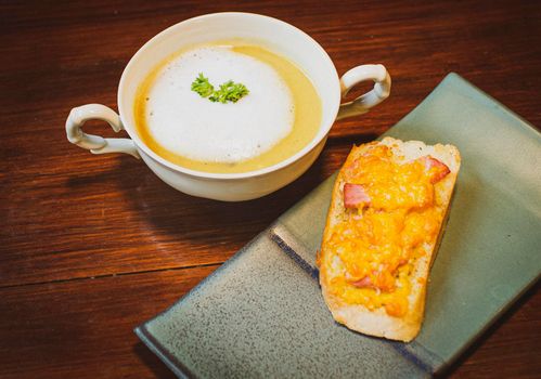 Mushroom Soup with Garlic Bread on ceramic plate on the wooden table.