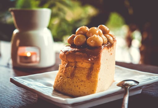 Macadamia Caramel Cake homemade dessert sweet cake on white ceramic plate with spoon.