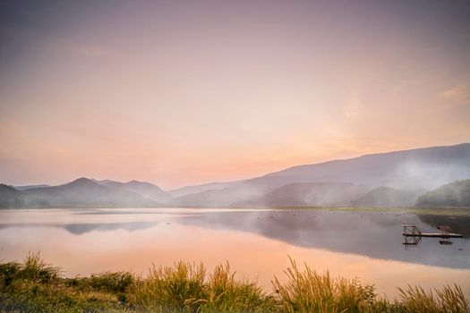 idyllic  Dramatic Sunset with the scene of fog Over The Lake Mountains on background at Khao Luang Reservoir. in Sukhothai Thailand