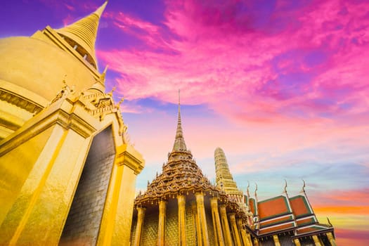 Golden Stupa of Temple of the Emerald Buddha.  Wat Phra Si Rattana Satsadaram.  Wat Phra Kaew. landmark of Bangkok Thailand with pink sky at dusk