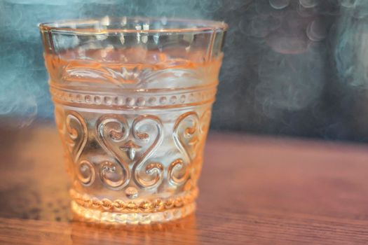 Drinking water in beautiful vintage whisky amber color glasses object on blur background.
