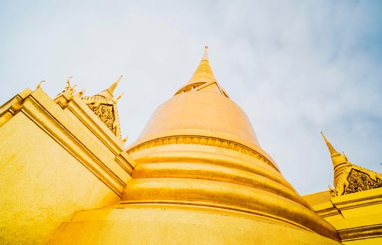 Golden Stupa of Temple of the Emerald Buddha.  Wat Phra Si Rattana Satsadaram.  Wat Phra Kaew. landmark of Bangkok Thailand with pink sky at dusk