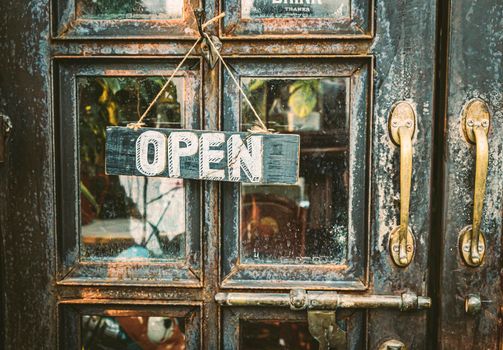 Open Sign Hanging on vintage door for decoration and comunication with people.