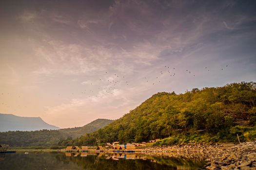 Panorama View of tropical lake and mountains. Small bamboo traditional cottage next the lake in Sukhothai Thailand