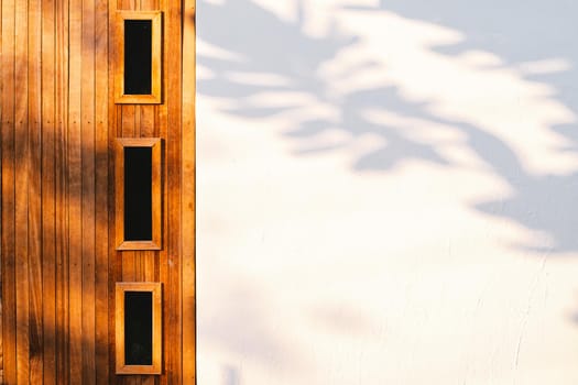 Wooden door white wall with Tree leaves shadow on wall Nature Abstract background