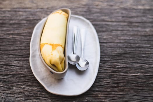 Banana crepe sweet dessert object still life. The crepe put in the ceramic container bowl banana shape form design.