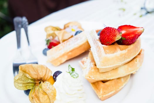 Homemade breakfast  Strawberry and tropical fruits  Waffles with  chocolate syrup