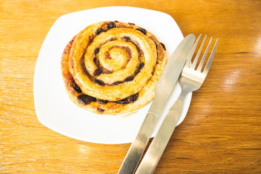 Cinnamon rolls buns baking on a white plate breakfast table Top view.