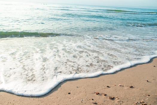 Close Up Wave Sand Beach Sea Foam.  Closeup of sea wave with foam on beach sand. Vacation Summer background