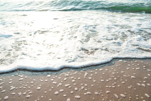 Close Up Wave Sand Beach Sea Foam.  Closeup of sea wave with foam on beach sand. Vacation Summer background