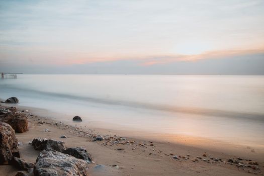 long exposure Sea rocks landscape Magnificent sunrise view at sunrise Romantic atmosphere in peaceful morning at sea. Pink horizon with first hot sun rays.