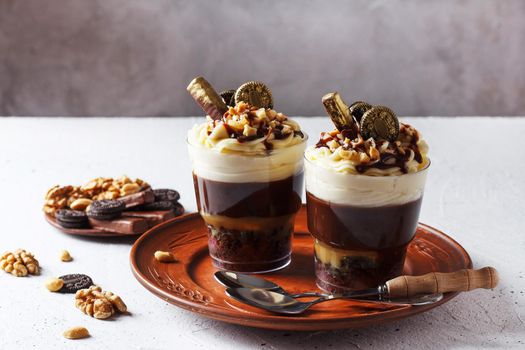 Delicious chocolate trifle or pudding with whipped cream in a glass on a gray background. copy space