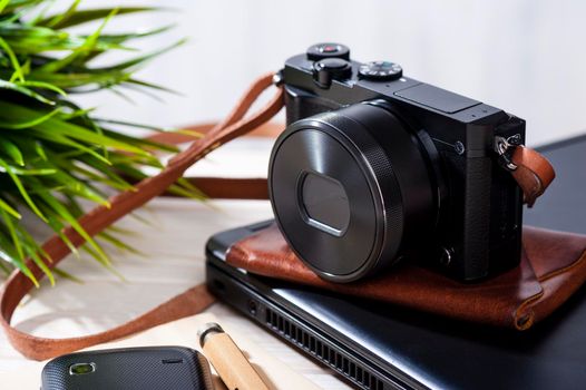 closeup vintage style of digital mirrorless camera with leather strap.