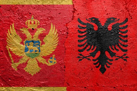Montenegro and Albania - Cracked concrete wall painted with a Montenegrin flag on the left and a Albanian flag on the right