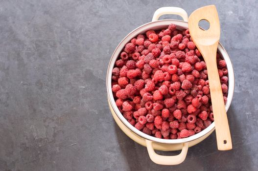 a full pan of ripe raspberries and a spoon for jam, a large harvest of healthy berries, a healthy diet, Favorite delicacy, preservation of Natural vitamins for the winter