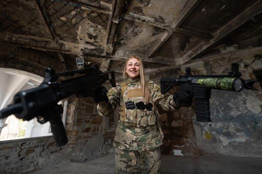 Caucasian woman in army uniform holding two machine guns