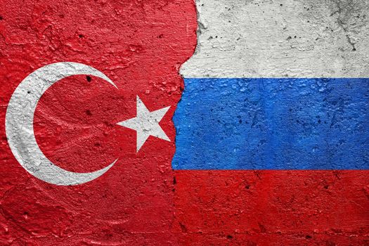 Turkey and Russia - Cracked concrete wall painted with a Turkish flag on the left and a Russian Federation flag on the right