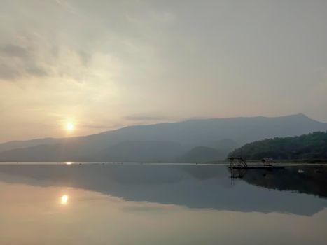 Bamboo raft floating in lake with mountain background. Lake reflection beautiful nature