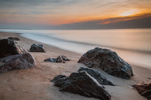 long exposure Sea rocks Magnificent sunrise view at sunrise Romantic atmosphere in peaceful morning at sea. Pink horizon with first hot sun rays.