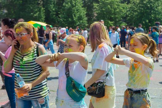 Novokuznetsk, Kemerovo region, Russia - June 12, 2022 :: Children with colorful faces painted with holi powder having fun outdoors.