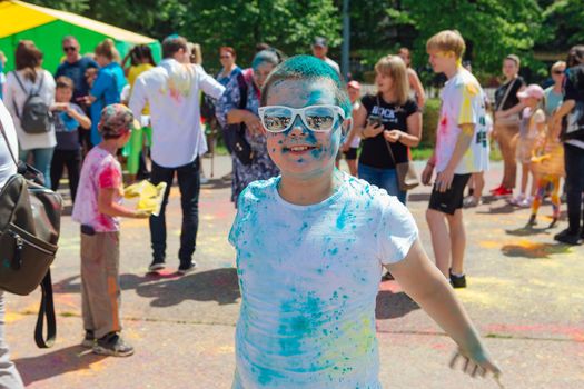 Novokuznetsk, Kemerovo region, Russia - June 12, 2022 :: Boy with colorful face painted with holi powder having fun outdoors.