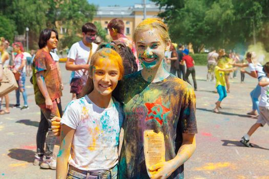 Novokuznetsk, Kemerovo region, Russia - June 12, 2022 :: Children with colorful faces painted with holi powder having fun outdoors.