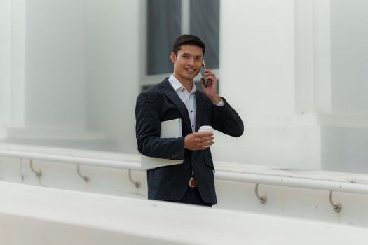 Portrait of Asian Business man talking and dealing with customer by cell phone. Account and Finance concept