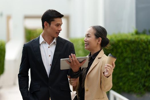 Portrait of Asian Senior Business woman and young business man discussing about Real Estate project