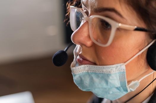 Female employee of the call center took off the medical mask at the workplace