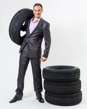 Car dealer man over tire tire background. Auto maintenance.