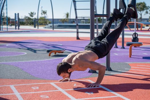 Shirtless man doing loop exercises outdoors