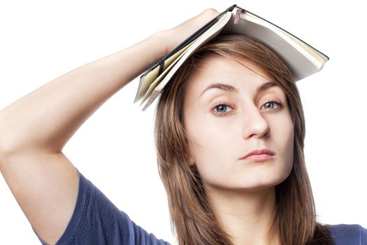 Education. Tired girl holds a notebook on her head on a white background