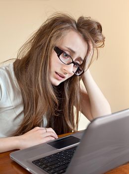 Young woman in glasses frustrated on the computer