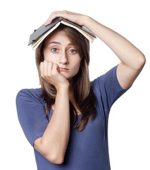 Education. Tired girl holds a notebook on her head on a white background