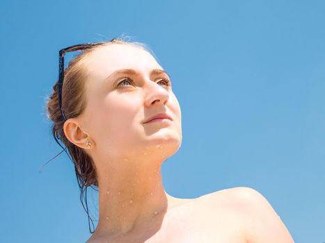 Portrait of an young beautiful woman sunbathing against blue sky