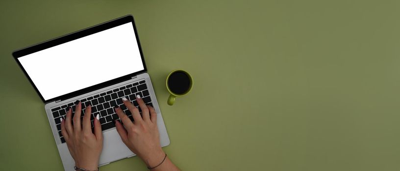 Woman using laptop computer on green background with copy space. Top view.