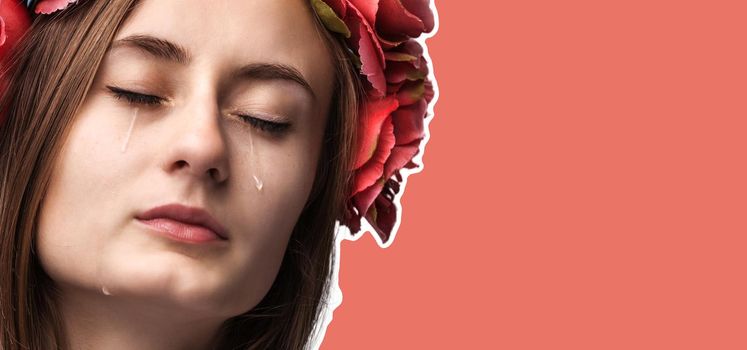 Close-up portrait of beautiful crying girl with tears. Magazine style collage with copy space and trendy coral color background