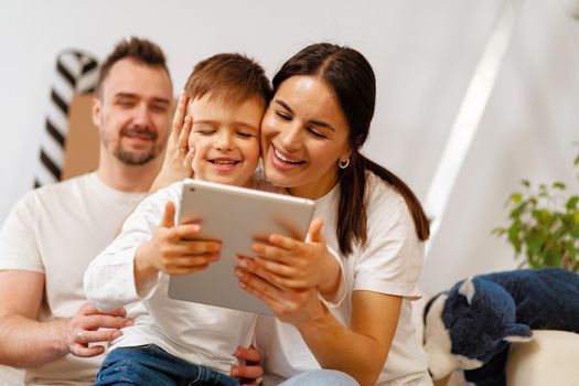 Portrait of happy family with cardboard boxes in new house at moving day, close up