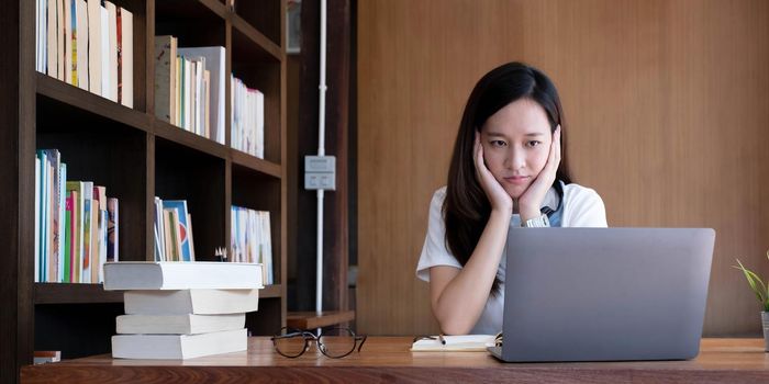 Asian women are bored from their online studies, have a sad face and have been tired from their studies for a long time..