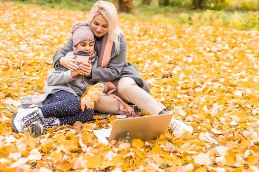 Mother and daughter in autumn yellow park